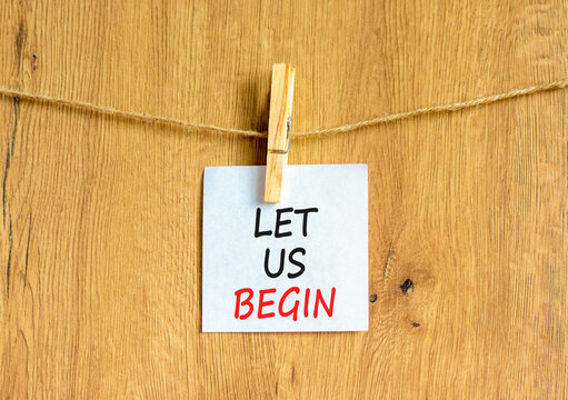 Let us begin symbol. Concept words Let us begin on beautiful white paper on clothespin. Beautiful wooden background. Business motivational let us begin concept. Copy space.