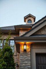 Naklejka premium Captivating Evening View of a Luxurious Home's Exterior, Showcasing Exquisite Stonework and Architectural Details