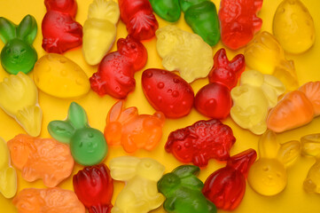 A vibrant assortment of gummy candies shaped like Easter bunnies, chicks, and carrots. Bright and playful confectionery art, perfect for festive designs and ads.