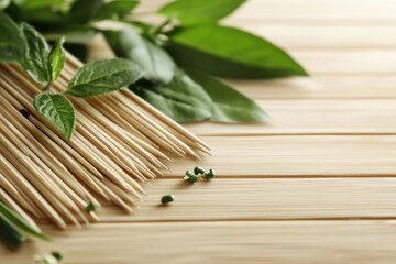 Wooden skewers with fresh herbs on light wood background