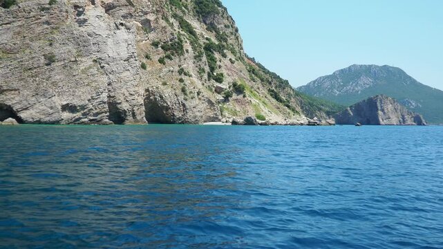 Pecina cave, beach Miina plaza, Bar Montenegro. Hills, inaccessible rocks. Flysch, marine sedimentary rocks, lithological layers. Adriatic Mediterranean. Boat trip on the sea. Summer sea tourism
