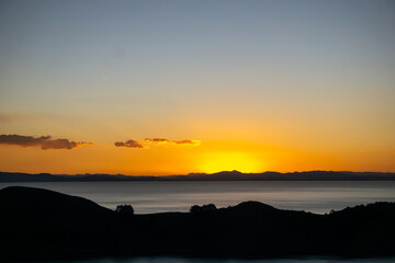 Fototapeta premium Golden Sunset on Lake Titicaca from the Island of the Sun, Highlighting the Calm Water and Dramatic Landscape