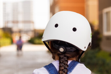 Niña aprendiendo a montar bicicleta de equilibrio al aire libre con su casco