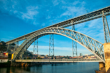 Fototapeta premium Don Luis I Bridge. The majestic arch bridge over the Douro River in Porto, Portugal, on a sunny day. An impressive engineering feat, a historical landmark, and a popular tourist destination.
