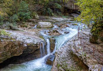 a stream of water in a stone riverbed, spewing noise and rumbling, making its way to free water