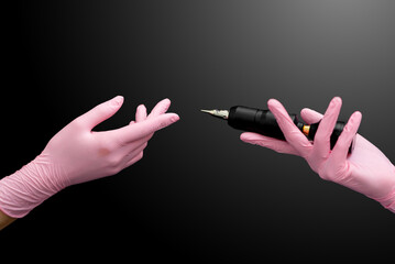 Permanent makeup. Hands of a girl in pink gloves holding a permanent machine on a black background

