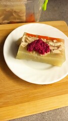 Traditional jellied meat dish served on a white plate