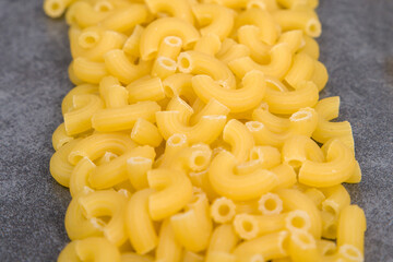Raw macaroni pasta  on grey background