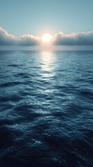 Fototapeta premium Sunrise over calm ocean waters with soft clouds in the background creating a serene morning atmosphere