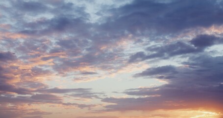 Obraz premium The plane flies among pink clouds covering the blue sky at sunset. Video in 4k, red komodo.