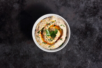 Bowl with baba ganoush, eggplant hummus on black background, from above overhead top view, traditional Middle Eastern cuisine concept