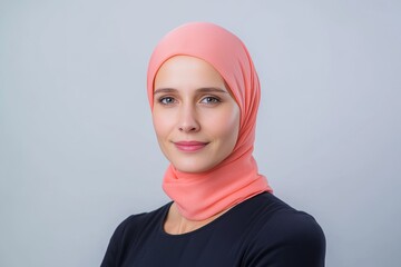 Happy woman in a coral hijab wearing a navy blue top