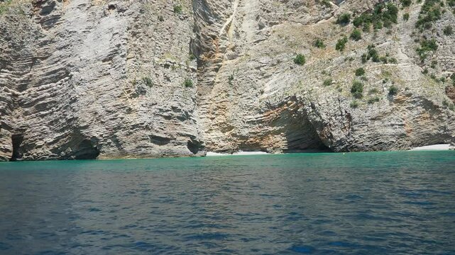 Pecina cave, beach Miina plaza, Bar Montenegro. Hills, inaccessible rocks. Flysch, marine sedimentary rocks, lithological layers. Adriatic Mediterranean. Boat trip on the sea. Summer sea tourism