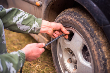 driver checking air pressure and filling air in the tires close up