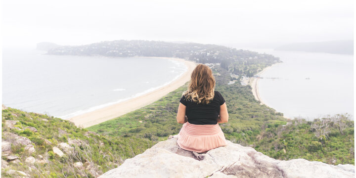 woman sitting on cliff Palm beach, Australia