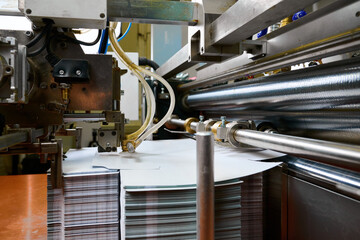 Precision adhesive application in a cutting-edge paper feed mechanism at a bustling manufacturing...