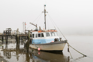 Fototapeta premium Fishing boat docked in Fog