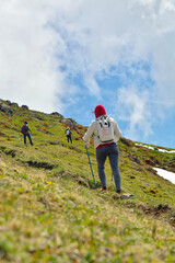 A girl traveler climbs to the top of an alpine mountain