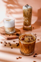 Ice coffee in a tall glasses with coffee beans around.