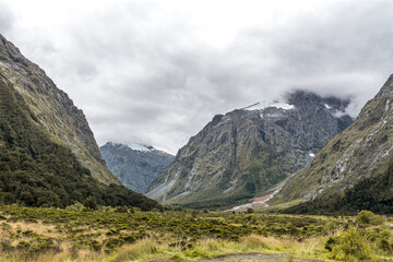Scenic nature with water, trees, mountains and clouds