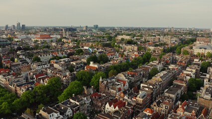 Obraz premium Panoramic aerial view from a drone, a view of the historic center of Amsterdam with narrow streets and a canal. Old traditional houses of the Netherlands.