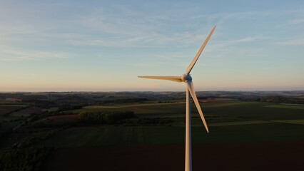 Fototapeta premium The drone flies at the level of the rotating blades of the wind generator around the propeller. Multicolored beautiful fields in the background, the Netherlands.