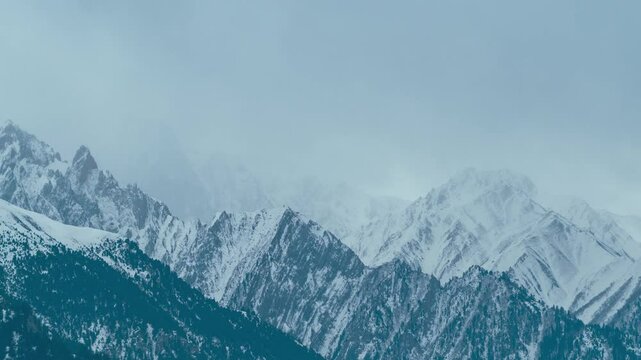 4K Time lapse shot of dark stormy clouds above the snowy Himalayan mountain peaks during the winter season at Sonmarg in Jammu and Kashmir, India. Winter stormy clouds above Himalayas of Pir Panjal.
