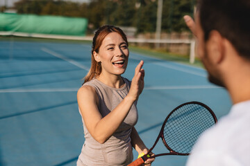 Young couple playing tennis outdoors enjoying a fun summer game