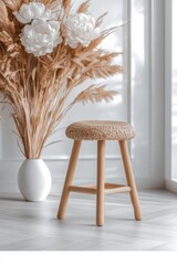 Neutral-toned room with a woven stool and pampas grass.