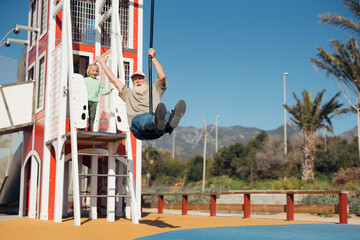 Grandparent and child sharing fun moments on the playground zipline