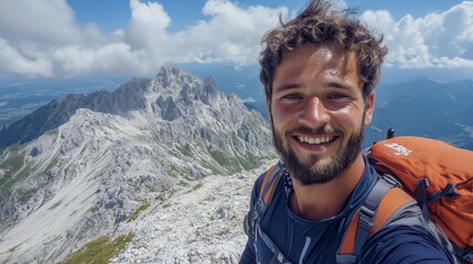 Naklejka premium Smiling young caucasian male hiker taking selfie on mountain peak with backpack
