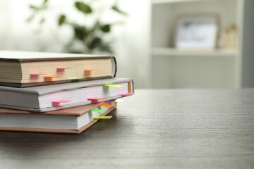 Books with colorful tabs on wooden table indoors, space for text