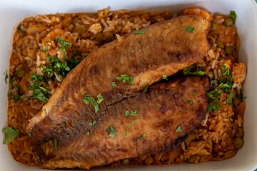 breaded and fried fish with shrimp risotto in a ceramic dish