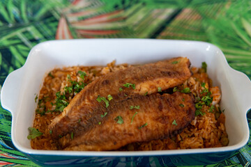 breaded and fried fish with shrimp risotto in a ceramic dish