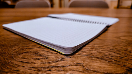 Fototapeta premium Open lined notebook and ballpoint pen on wooden table for study concept