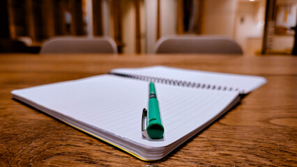 Open lined notebook and ballpoint pen on wooden table for study concept