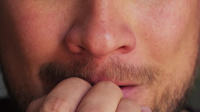 Person biting nail for anxiety or nervous habit of boredom, personal and stress. High quality 4k footage