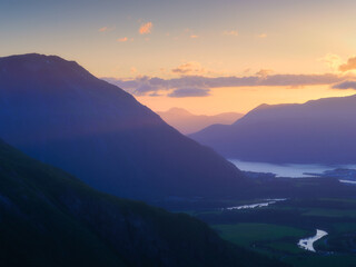Obraz premium Nature in Norway. Panoramic view of wild Norway. River and lake among the rocks and mountains. Bright sunshine during sunrise. Vacation and travel in summer north.