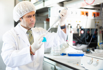 Fototapeta premium Diligent lab technician working with reagents in test tubes during chemical experiment