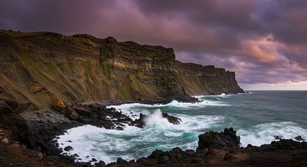 Ocean Waves Crashing Against Rocky Cliffs Under Dramatic Cloudy Sky