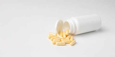 Mockup of a white bottle of medicine capsules, or food supplement, lying down on white background...