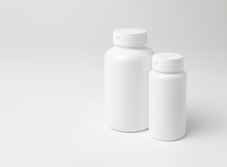 Mockup of two closed plastic medicine bottles, white background with copyspace, perfect for design mockups