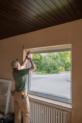 Fototapeta premium Carpenter Installing an Energy-Efficient Window in a House Renovation.