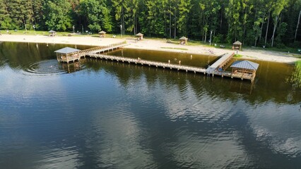 Wybrzeże jeziora w lesie z pomostem © Drone M8