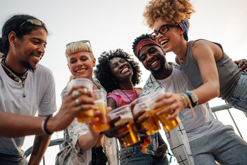 Happy friends toasting with beer at music festival