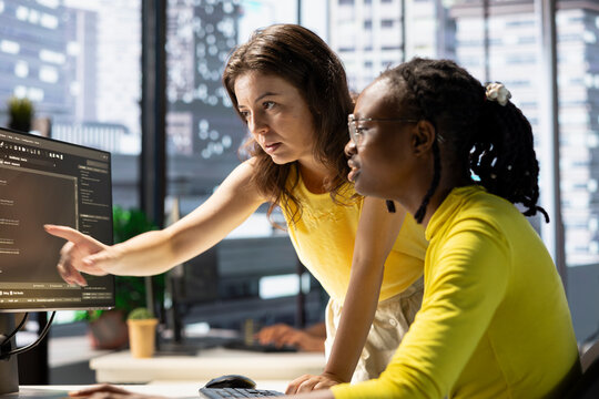 Manager correcting employee mistakes while conducting code review to fix bugs, identifying performance and technical issues with company software. Team leader supervising IT worker optimizing code