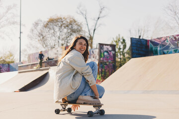 Close up of hipster girl riding skateboard at skate park. Copy space. © Zamrznuti tonovi