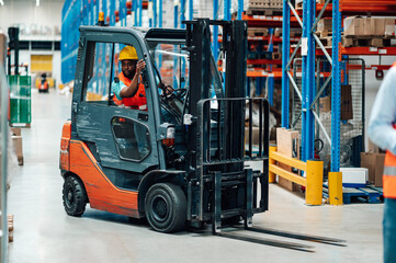 Warehouse worker driving forklift in logistics center