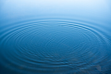 Circular water ripples and bubbles effect. Water ripples and round droplets on blue sea texture pattern background. Liquid motion on calm lake surface. Ring affect, circles