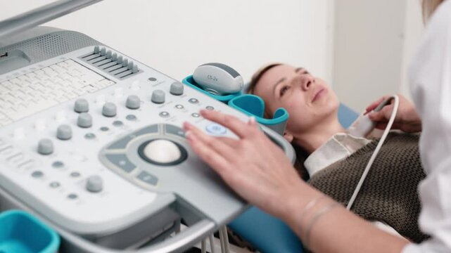 Close-up of a thyroid ultrasound. A doctor in blue gloves moves the probe on a young patient&rsquo;s neck. The concept of modern technology and precision in endocrine diagnostics.
